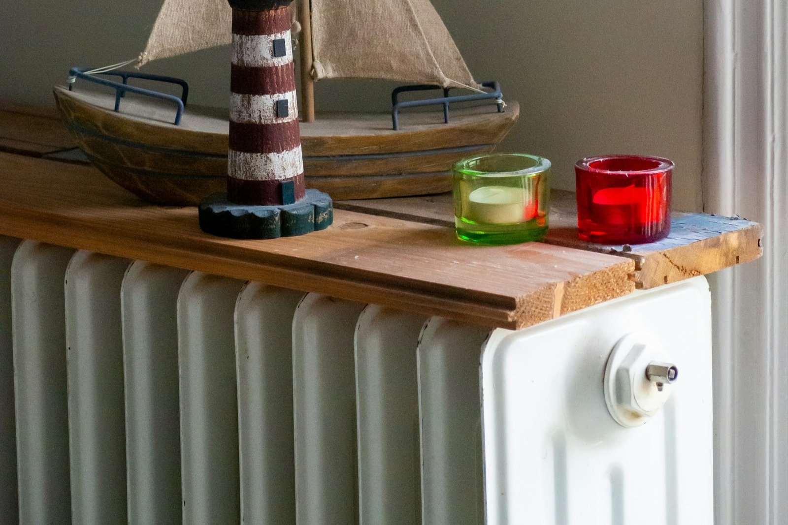 Hand mit Entlüftungsschlüssel am Ventil eines Heizkörpers