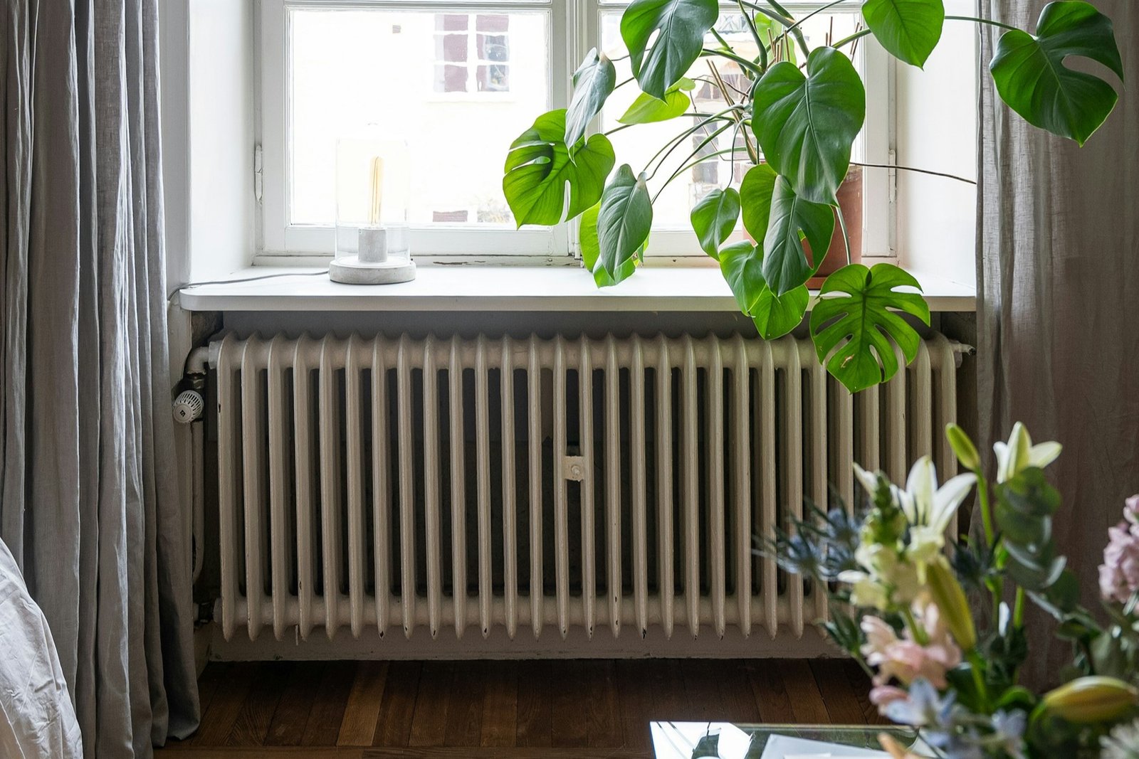 Weißer Heizkörper unter einem Fenster zu Beginn der Heizperiode