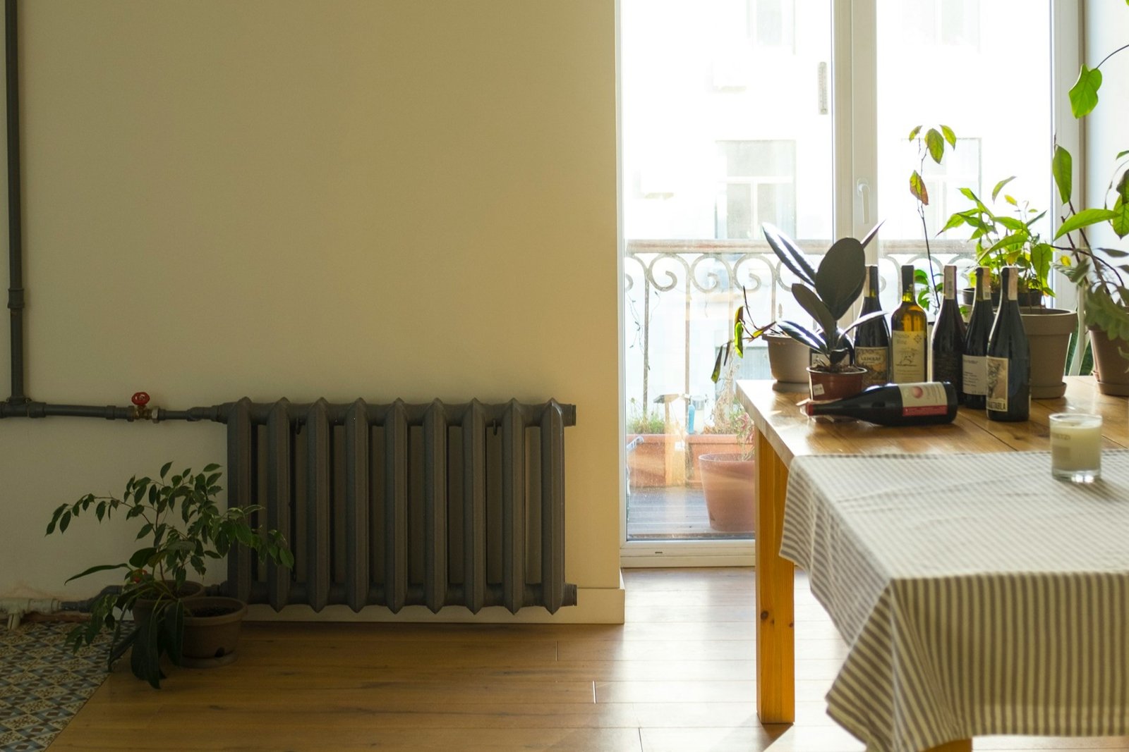 Weißer Heizkörper mit angeschlossenem Rohr an der Wand